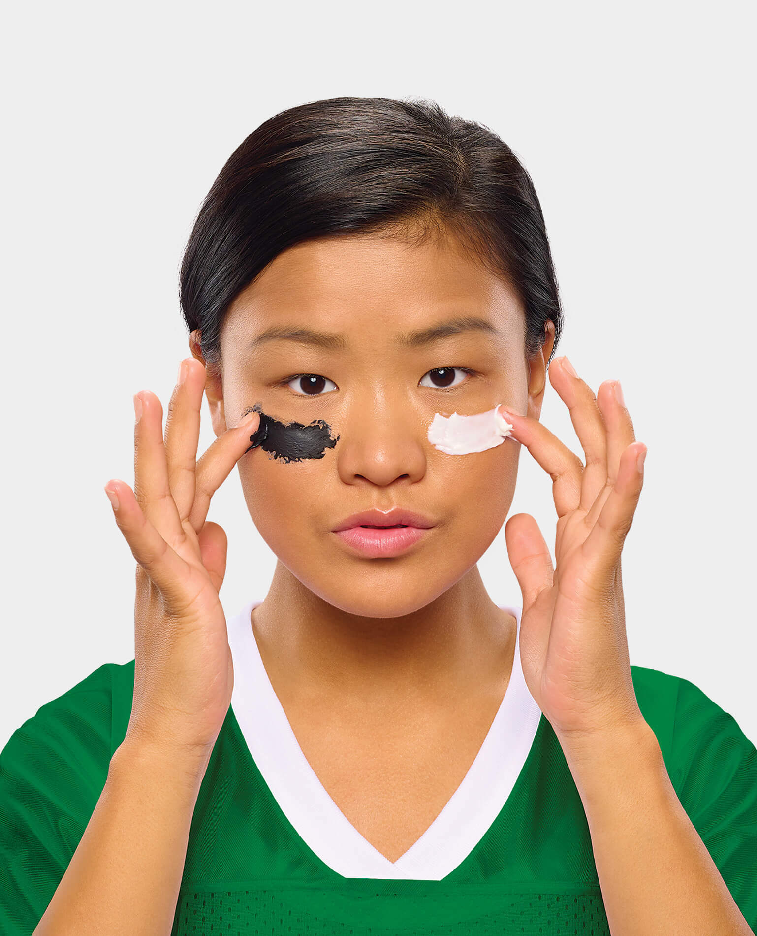 A woman applying a beauty face mask under her eyes like a football player.