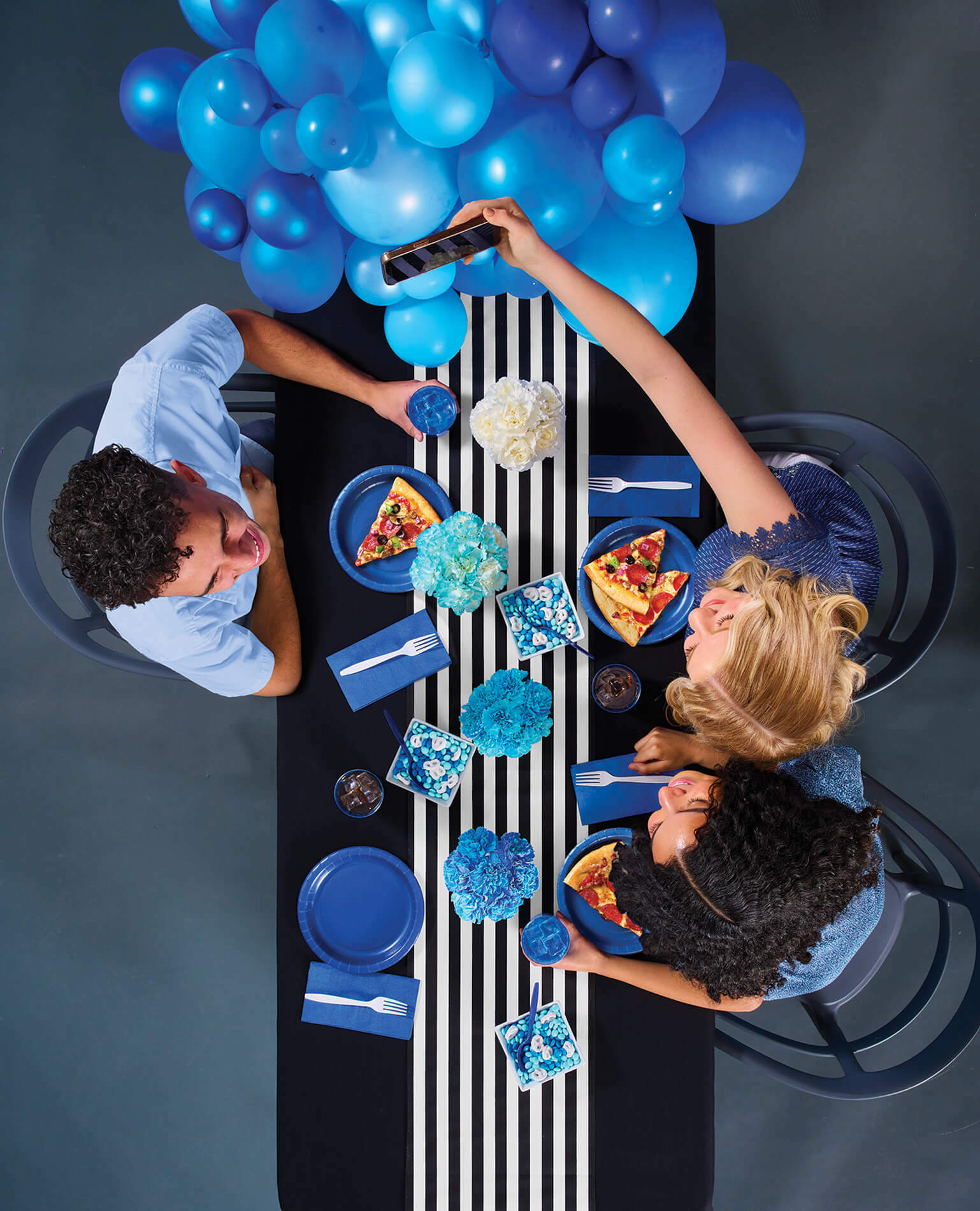 Three people sitting at a graduation party table shot from above.