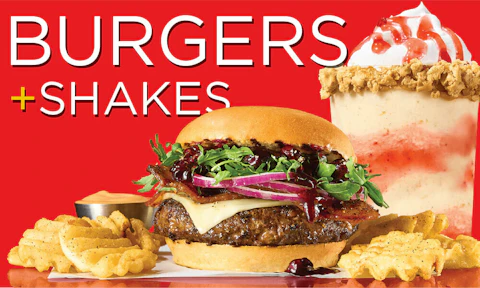 A juicy smash burger and fries rests in front of a peanut butter and jelly milkshake next to the title "Burgers + Shakes".