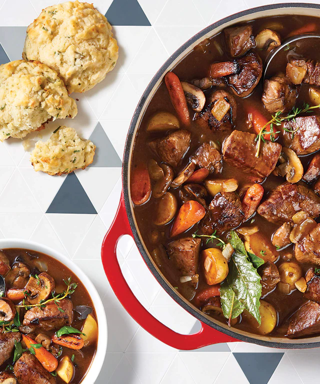 Pot and bowl of stew with some biscuits