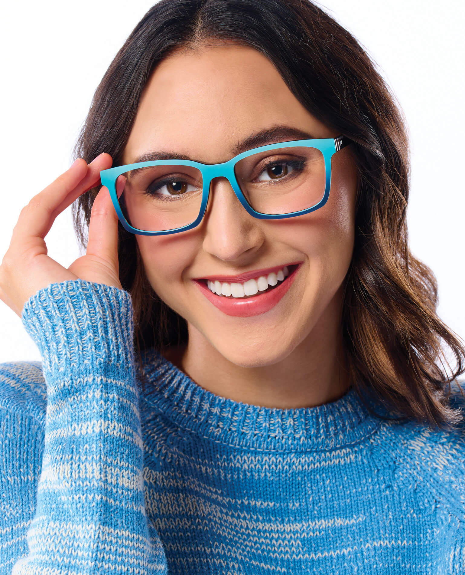 A smiling woman wearing blue glasses in a blue sweater.