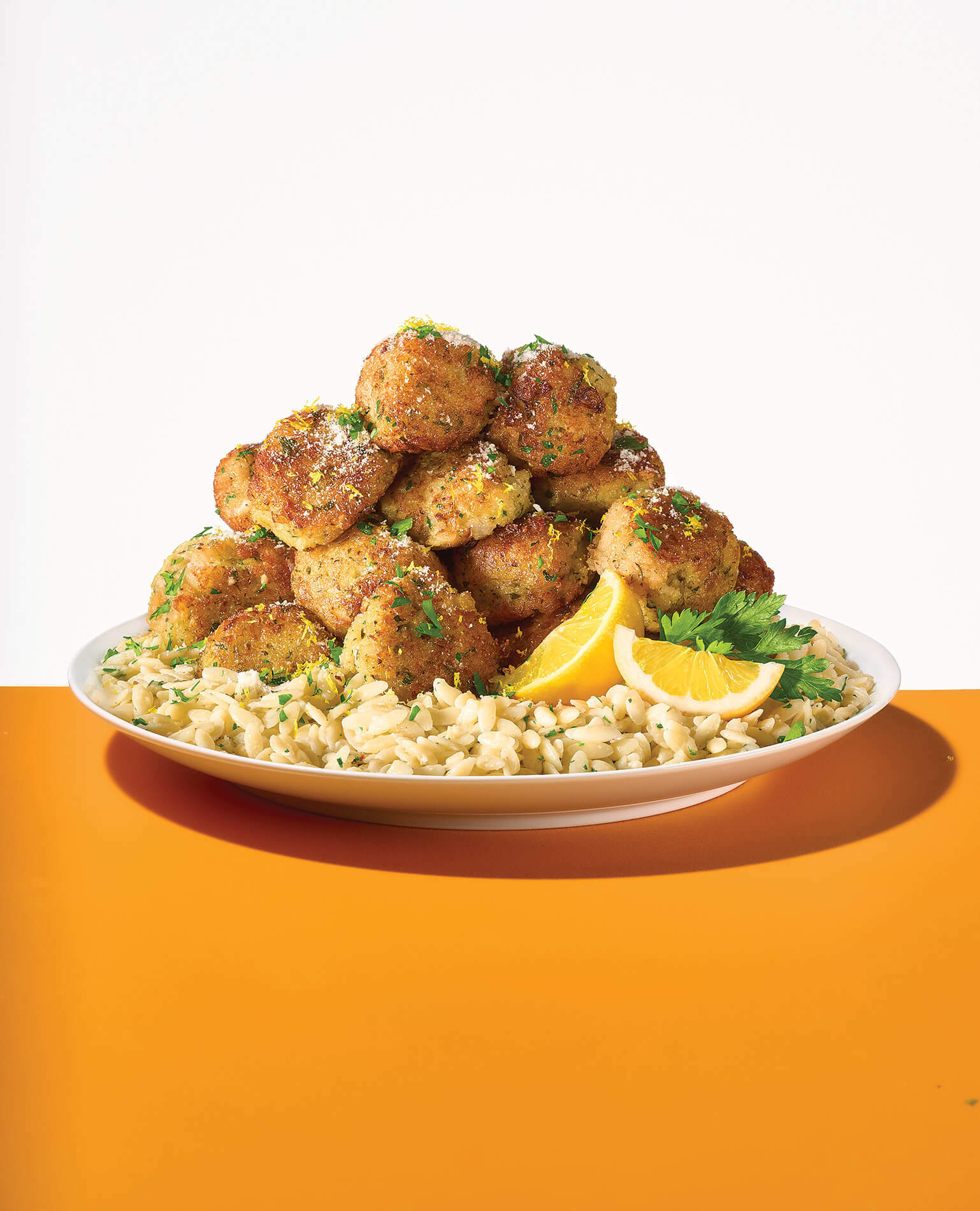 A plate of seafood meatballs with orzo.