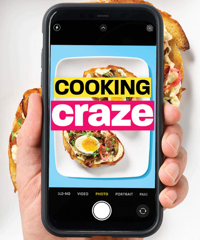 A hand holding a phone taking a photo of some food