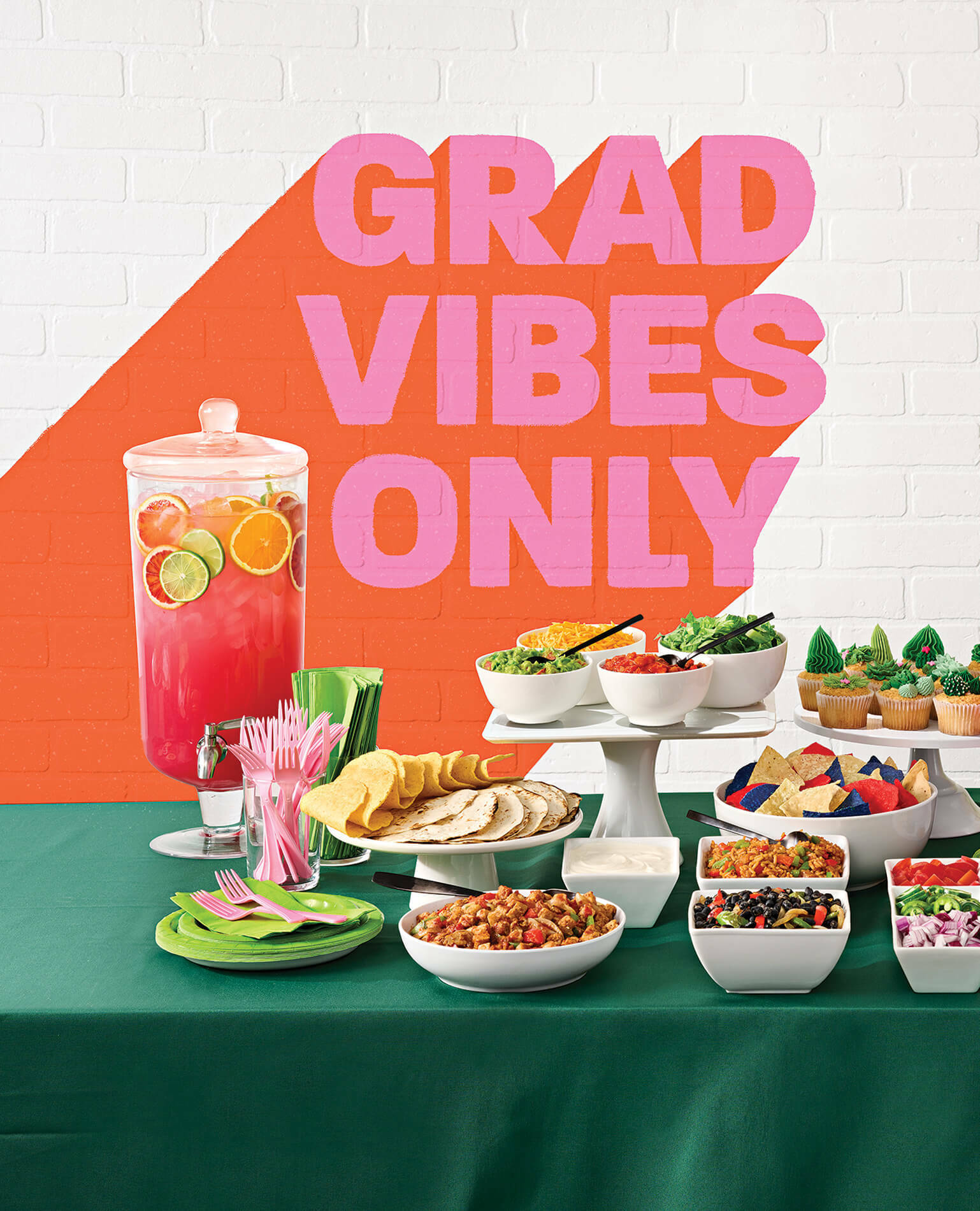 A table spread from a graduation party with the words "Grad Vibes Only" on the wall.