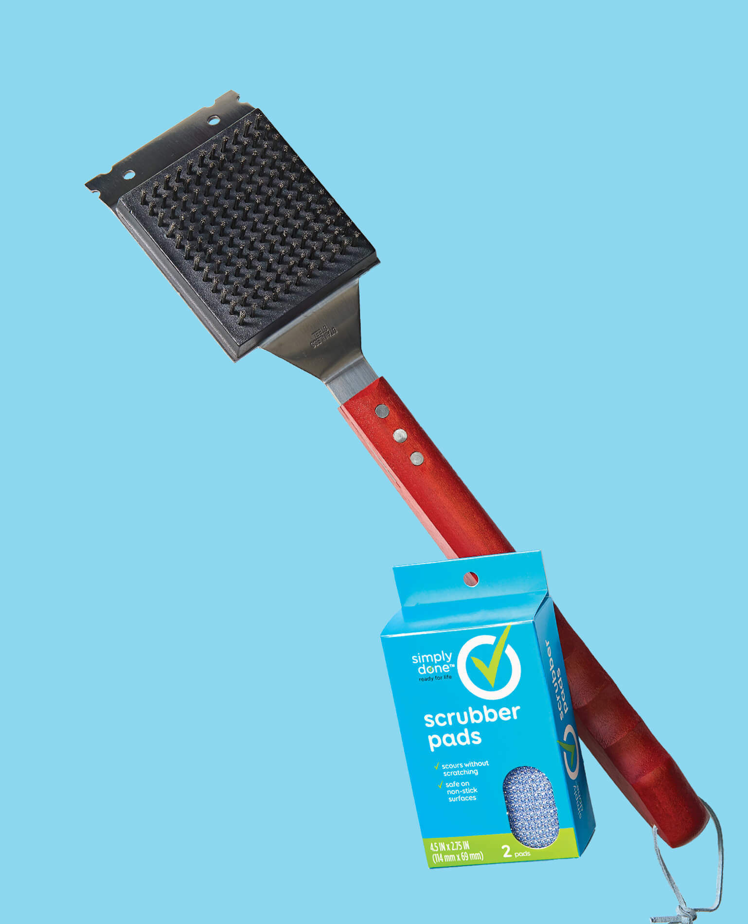 A grill brush and scrubbing pads on a blue background.