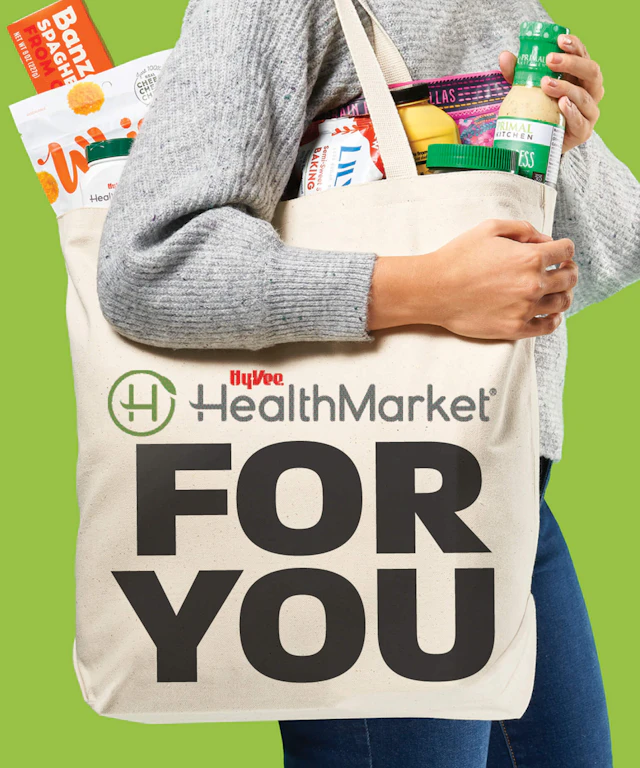 A woman holding a shopping bag with the words HealthMarket For You on it.