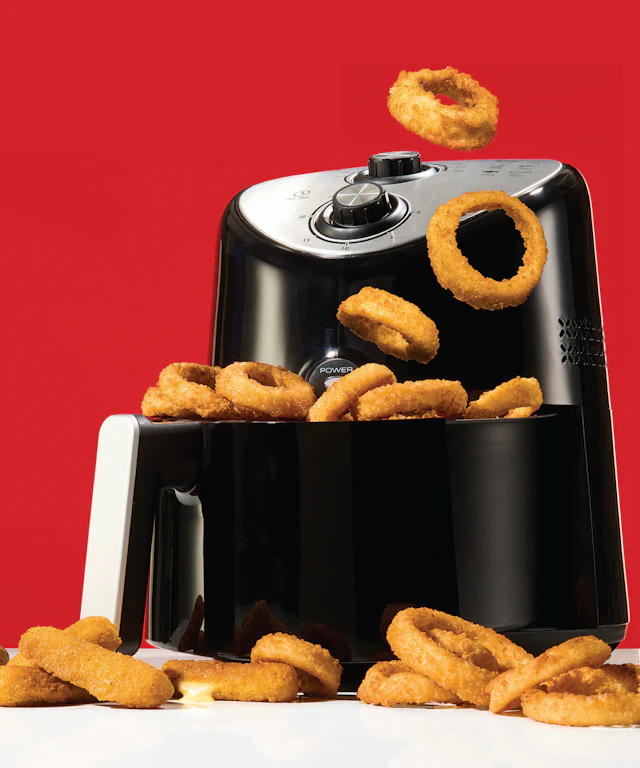 Hot air fryer with onion rings spilling out