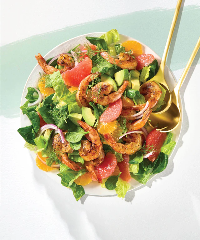 A bowl of a brightly colored shrimp and citrus salad.