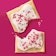 A broken up breakfast pastry on a pink background.