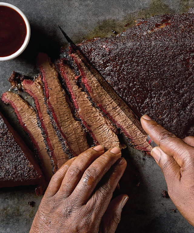 Closeup of Moe Cason slicing smoked brisket