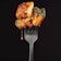 A forkful of juicy chicken on a black background.
