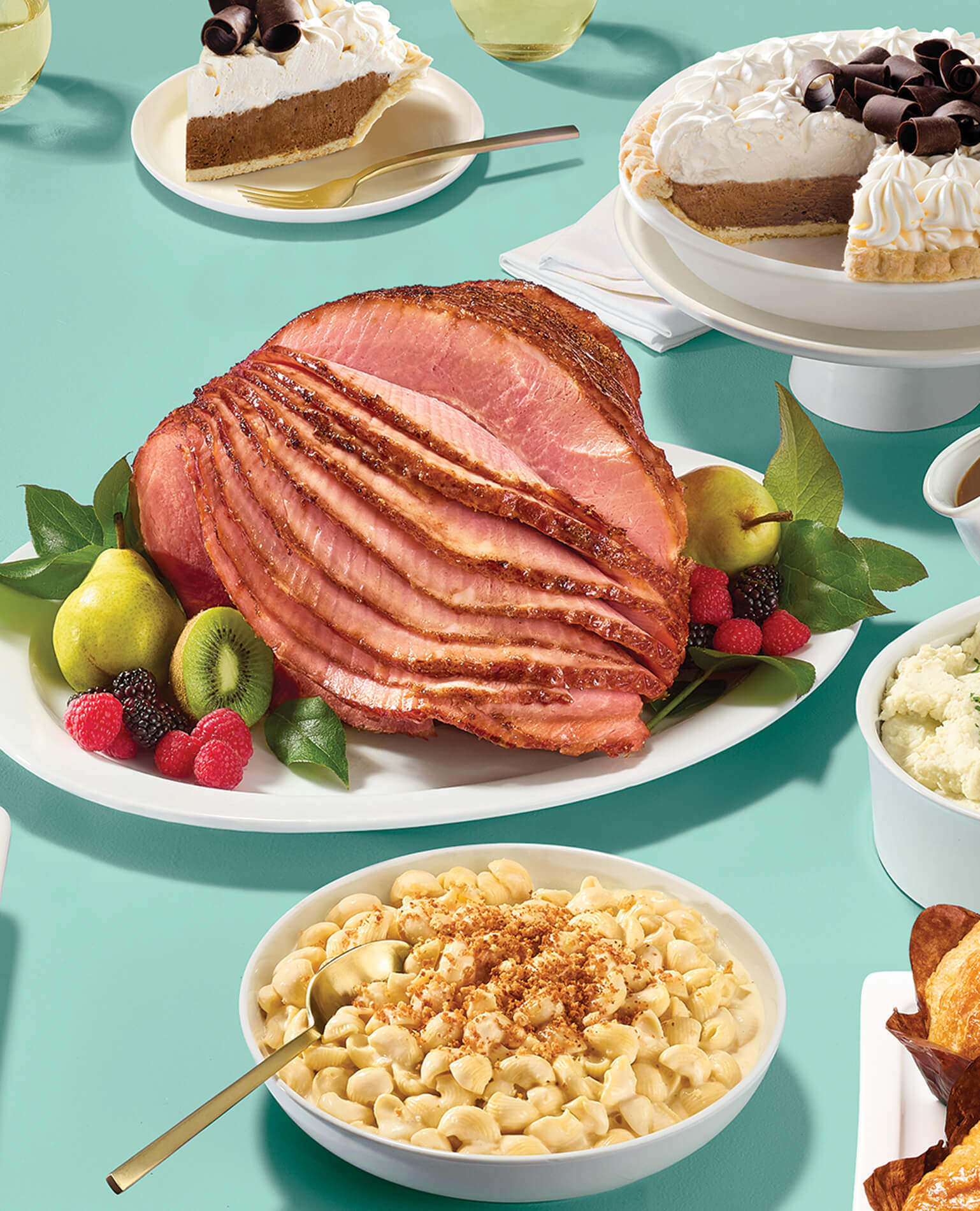 A full table spread for Easter dinner including ham, mac n cheese, and desserts.