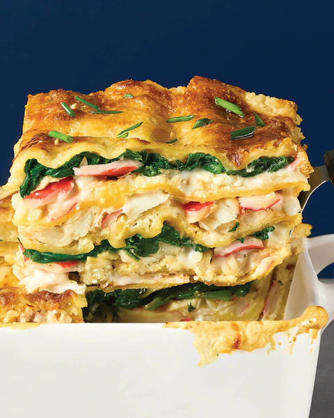 A slice of Cajun Seafood Lasagna being scooped out of a baking dish