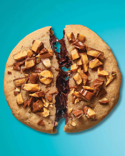 Almond Butter Chocolate Ganache Cookie split in two on a blue background