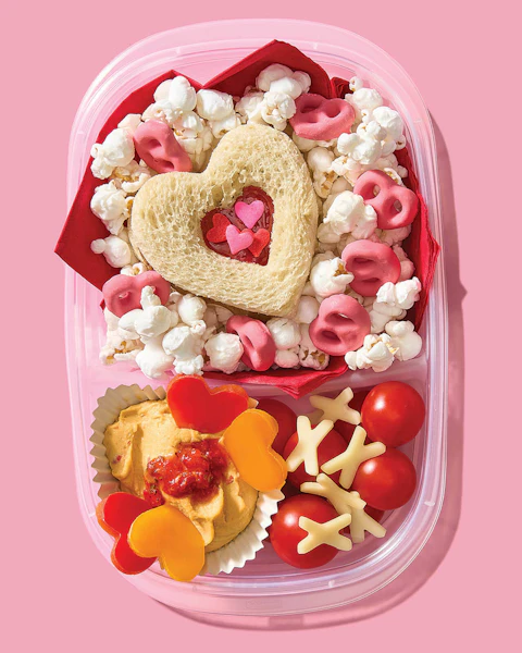 A compartmentalized box of Valentine's Day lunch and snack items