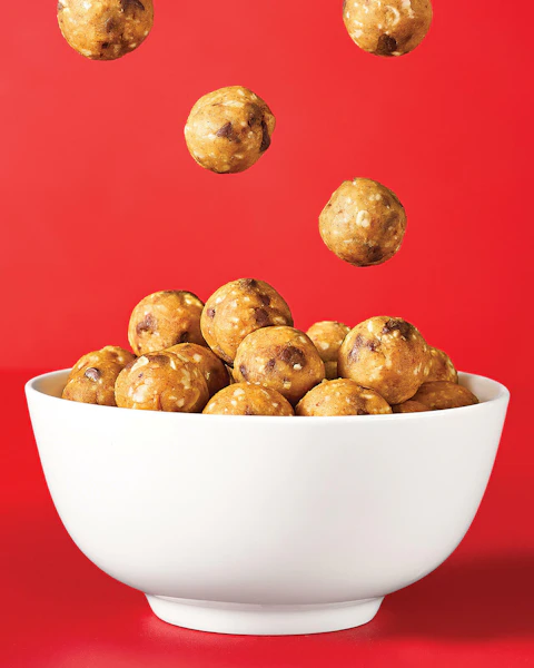 Garbanzo Bean Cookie Dough Bites falling into a white bowl