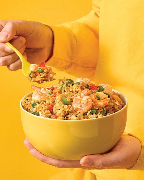 A woman holding a bowl of No Fry Fried Rice