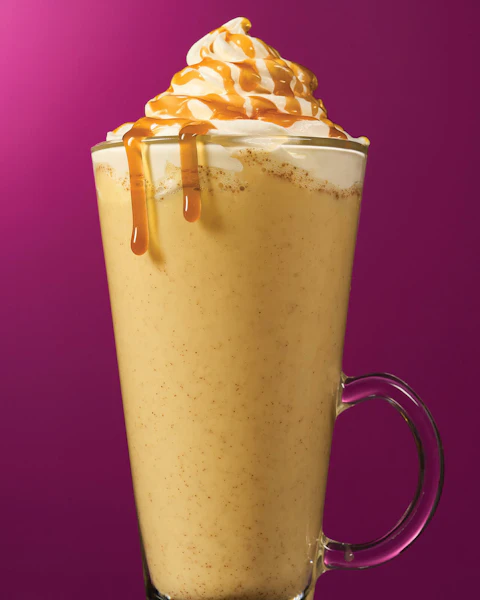A glass of Hot Butter Beer with caramel sauce dripping down