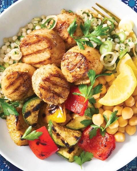 Israeli Couscous Scallop Bowl on a blue tile background