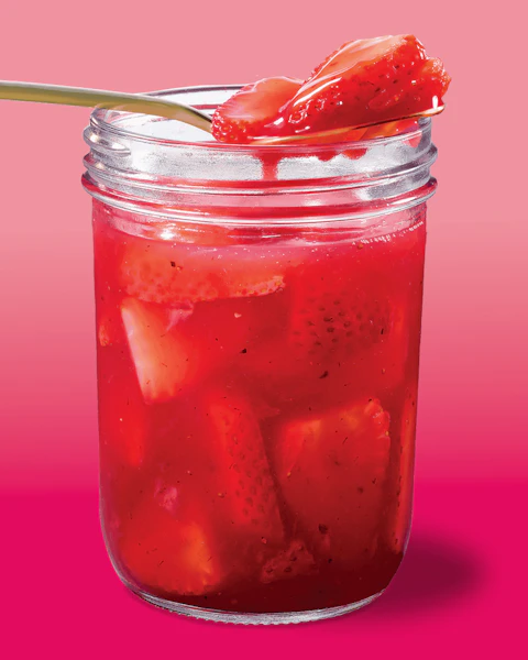 Jar of Savory Strawberry Compote being scooped out by a spoon.
