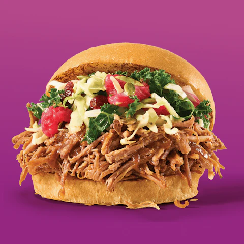 Slow Cooker Raspberry Pulled Pork Sandwich on a purple background