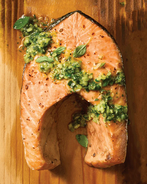 Salmon Steaks with Chimichurri cooked and served on a cedar plank