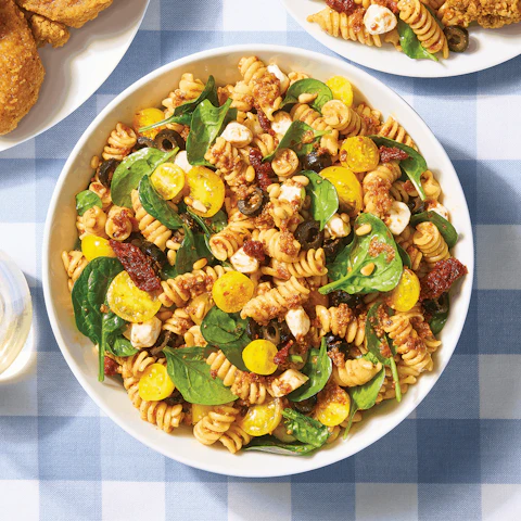 Bowl of Spinach and Sun Dried Tomato Pesto Fusilli on picnic blanket