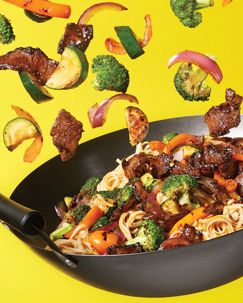 Wok flipping Five Spice Beef Stir Fry in the air