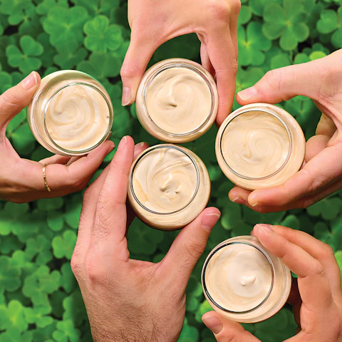 Four hands holding Baby Irish Coffee Shots in a cheers