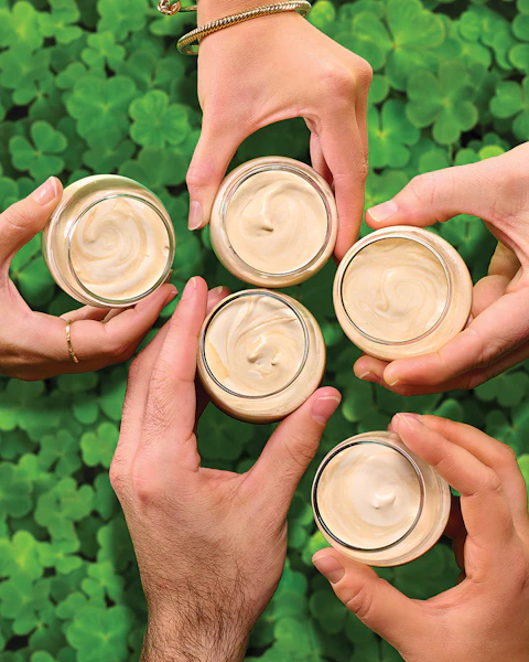 Four hands holding Baby Irish Coffee Shots in a cheers