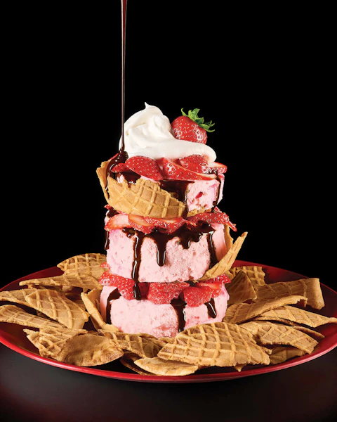 A plate of Sundae Nachos drizzled with chocolate sauce.