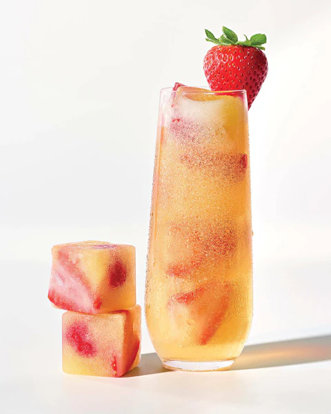 Mimosa Frozen Cubes next to a glass of mimosa cocktail