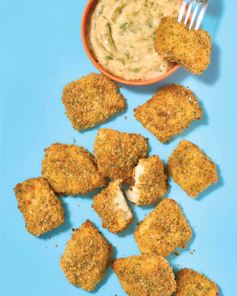 Oven Baked Fish Bites with Dipping Sauce on a light blue background