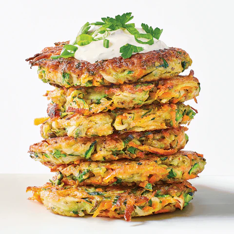 Stack of Carrot Zucchini Fritters topped with sour cream