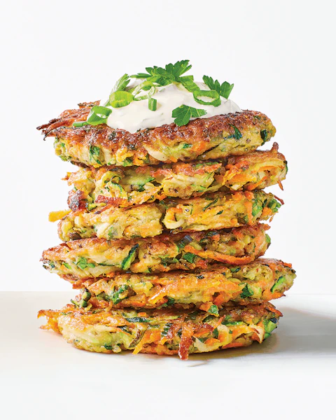 Stack of Carrot Zucchini Fritters topped with sour cream