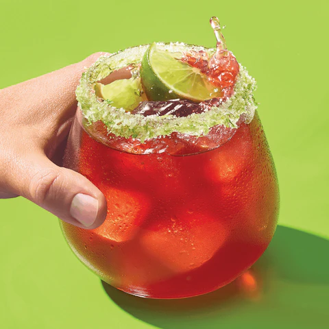 Hand holding a glass of Sparkling Cherry Hibiscus Margarita