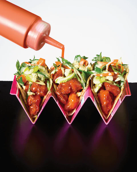 Three Buffalo Chicken Tacos with Carrot and Celery Slaw in a taco holder