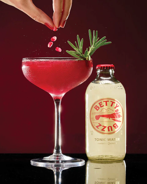 A glass of Buzzy Gin and Rosemary Cocktail, made with Betty Buzz.
