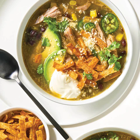 Bowl of Pork Carnitas and Tomatillo Soup with spoon