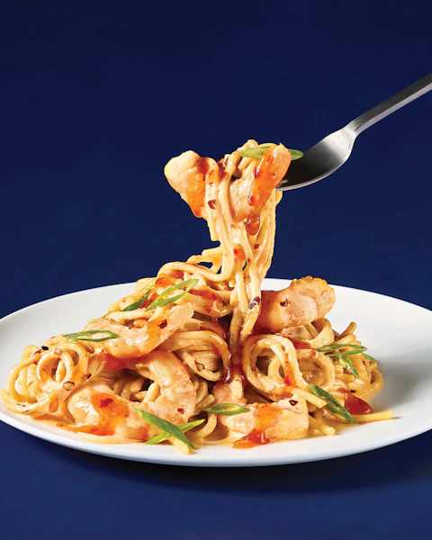 Plate of Instant Pot Spicy Shrimp Pasta being scooped with a fork