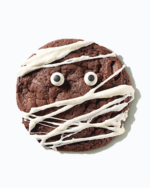 A cookie frosted and decorated to look like a mummy for Halloween.