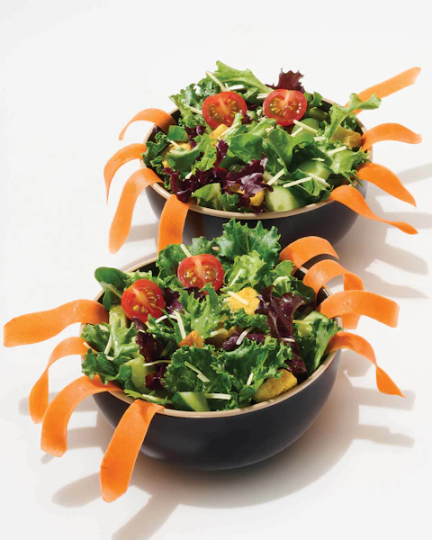 Two bowls of colorful salads made to look like spiders for Halloween
