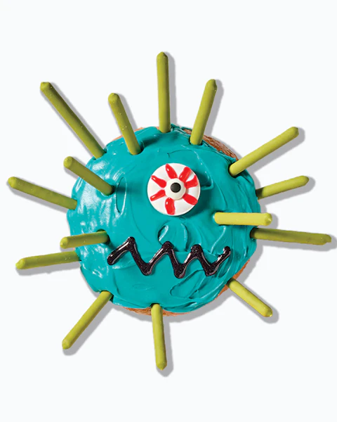 A donut frosted and decorated to look like a spikey monster