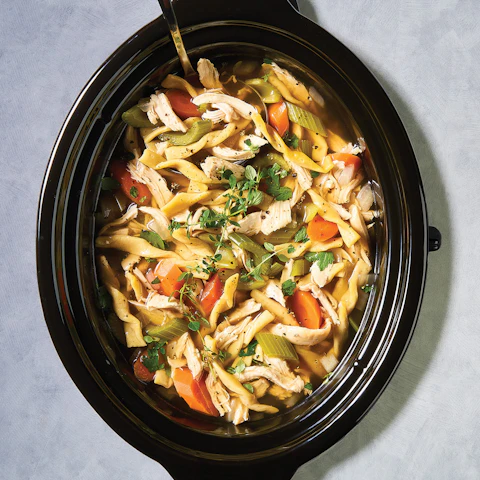 A crock pot of Slow Cooker Chicken Noodle Soup