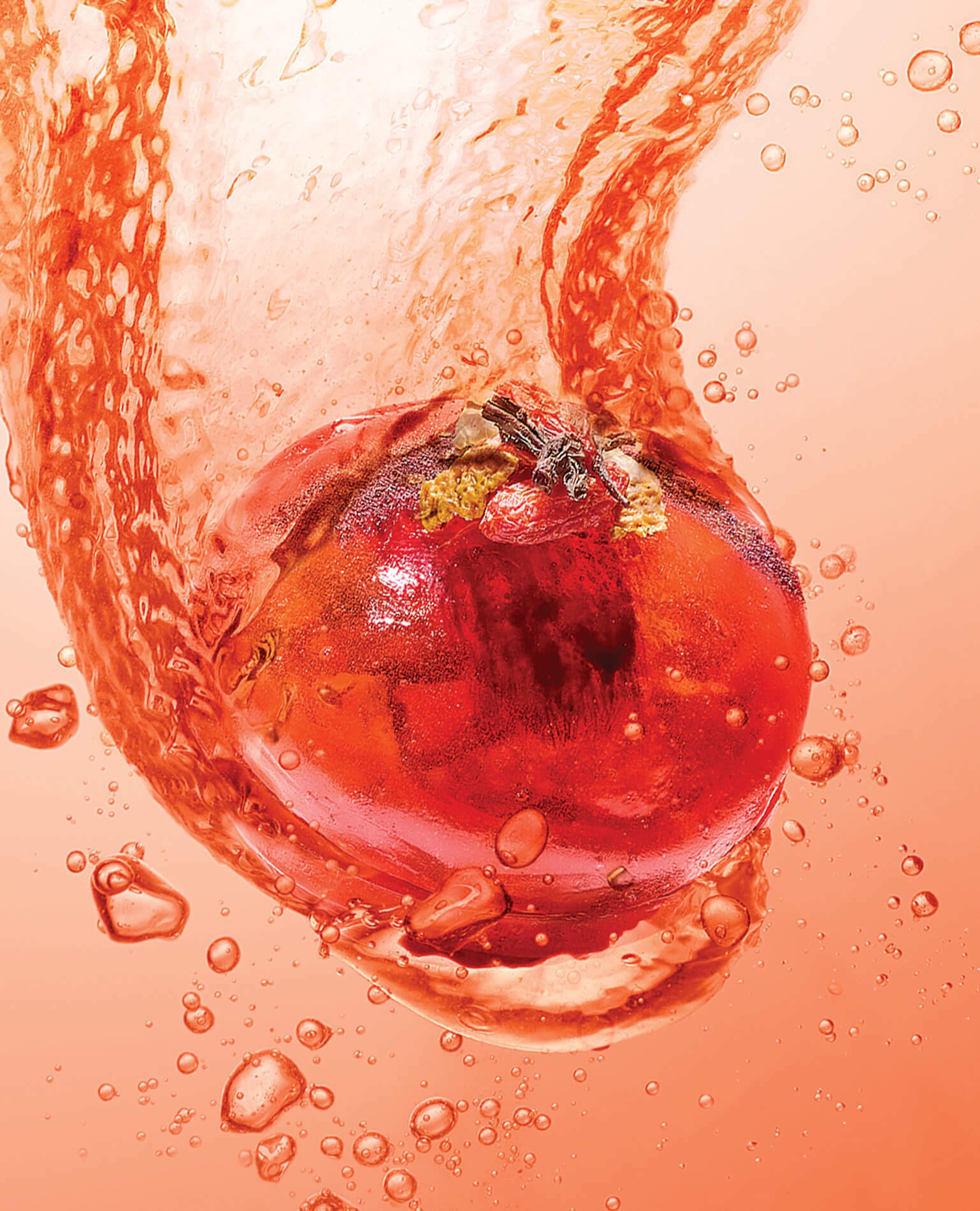 A red tea bomb plopping into a pinkish liquid.