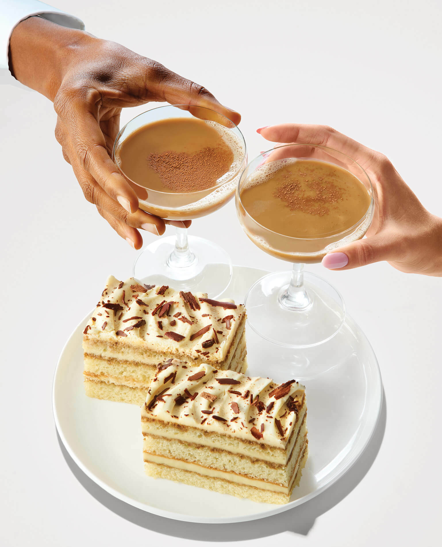 A man and a woman's hands clinking their drinks together, an example of a dessert and drink pairing from the Hy-Vee Wine & Spirits Department.
